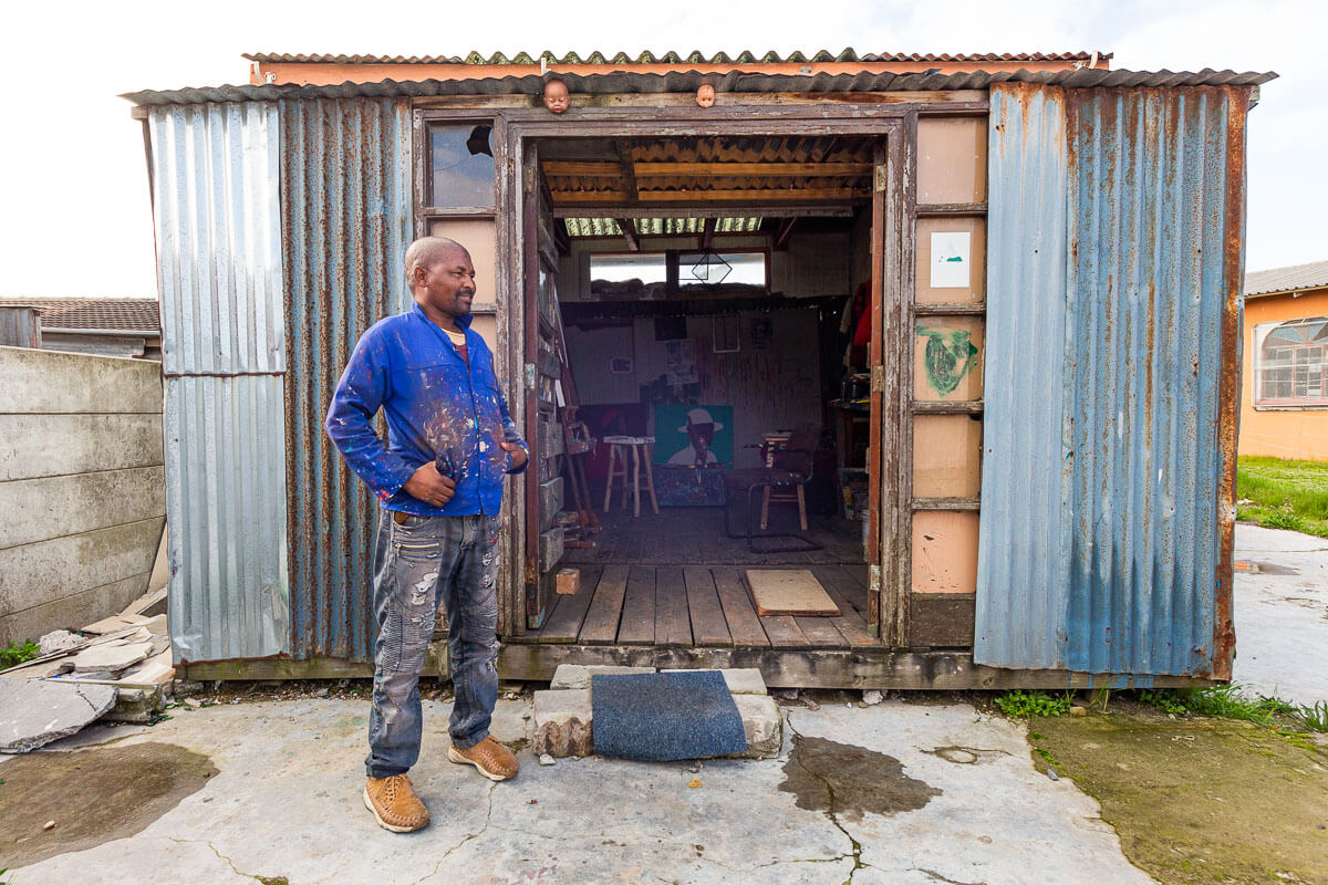Shakes Tembani stands outside his studio in Nyanga, Cape Town